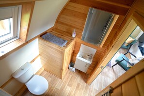 Une petite salle de bain comprenant des toilettes, un lavabo et un espace douche.