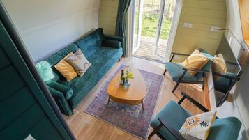 A cozy living area with a green sofa, a small wooden coffee table, and a chair.