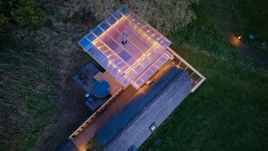 Luchtbeeld van een pand met een groot terras, een hottub en een houten constructie.