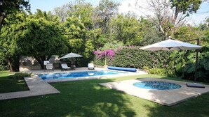 A backyard with a swimming pool, a hot tub, and a covered seating area. - Zapote House (Malinalco)
