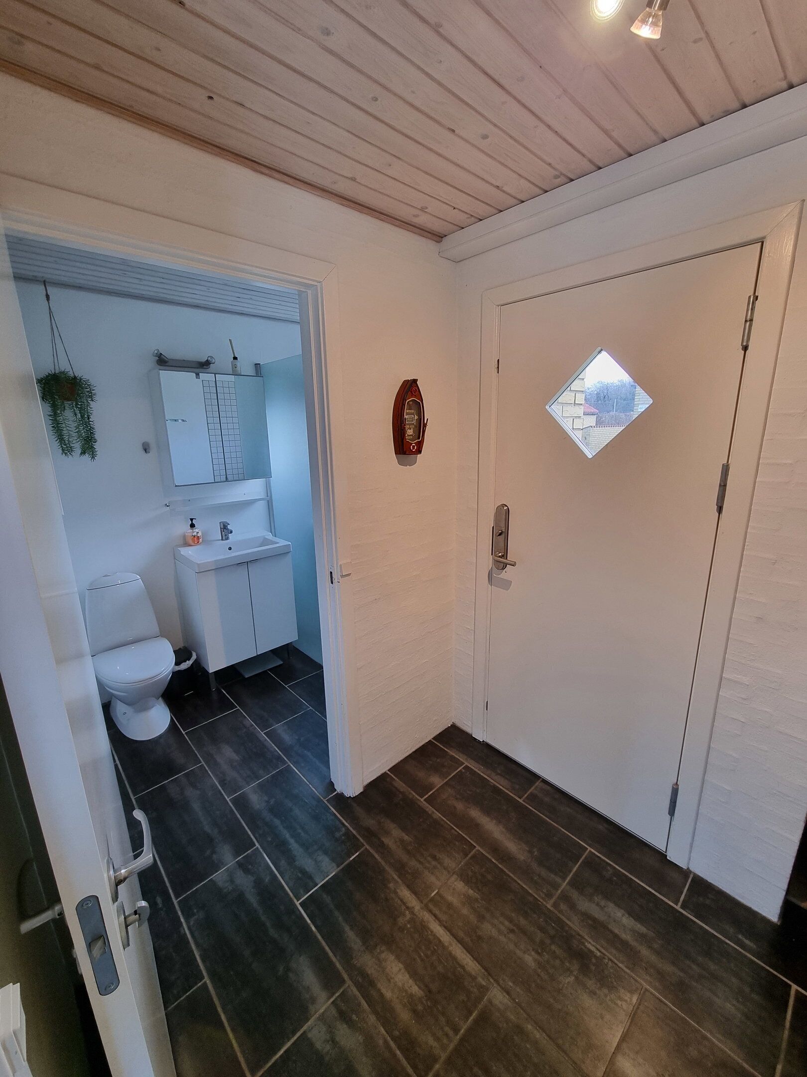 Kylpyhuone, jossa on wc, pesuallas ja peili.