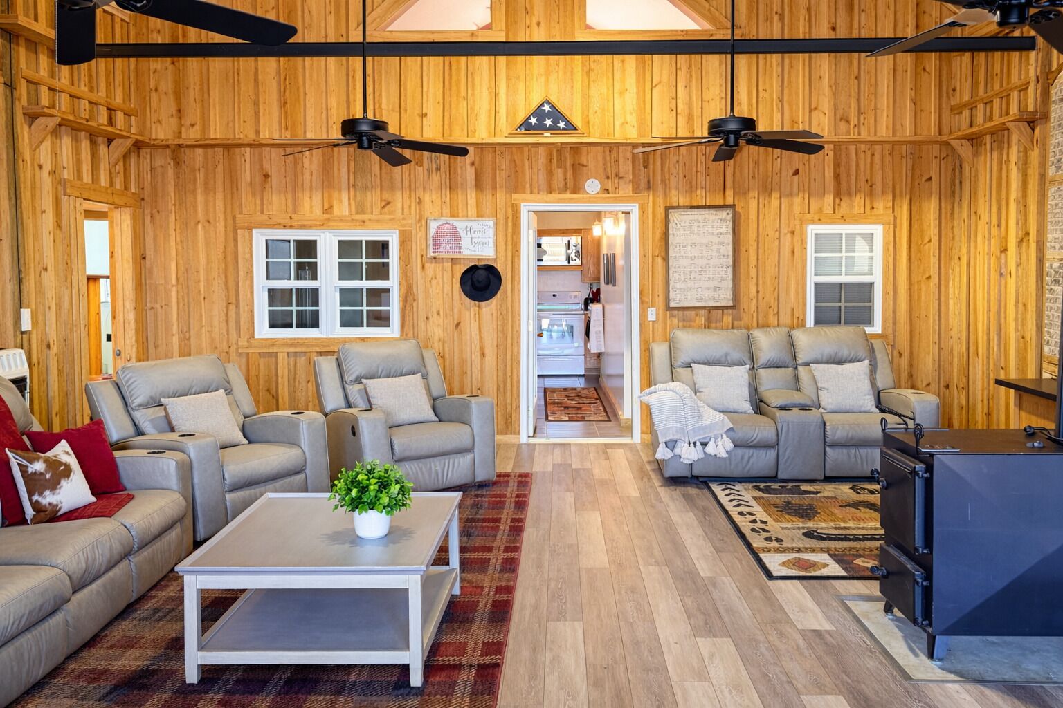 Ein gemütliches Wohnzimmer mit Holzwänden, zwei Sofas, einem Couchtisch und Deckenventilatoren.