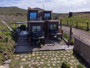 Enjoy a scenic view from this two-story residence with large windows and outdoor seating areas.