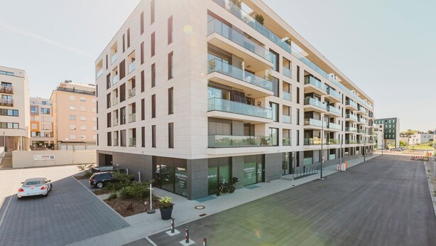 Un edificio de varios pisos con un diseño arquitectónico moderno, con balcones y ventanas amplias.