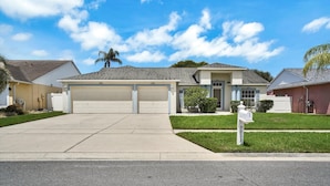 A residential house with a garage, a well-maintained lawn, and a mailbox. - Tampa Paradise For All Occasions (Riverview)