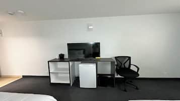 A modern hotel room with a flat-screen TV, a desk with a chair, and a bed.