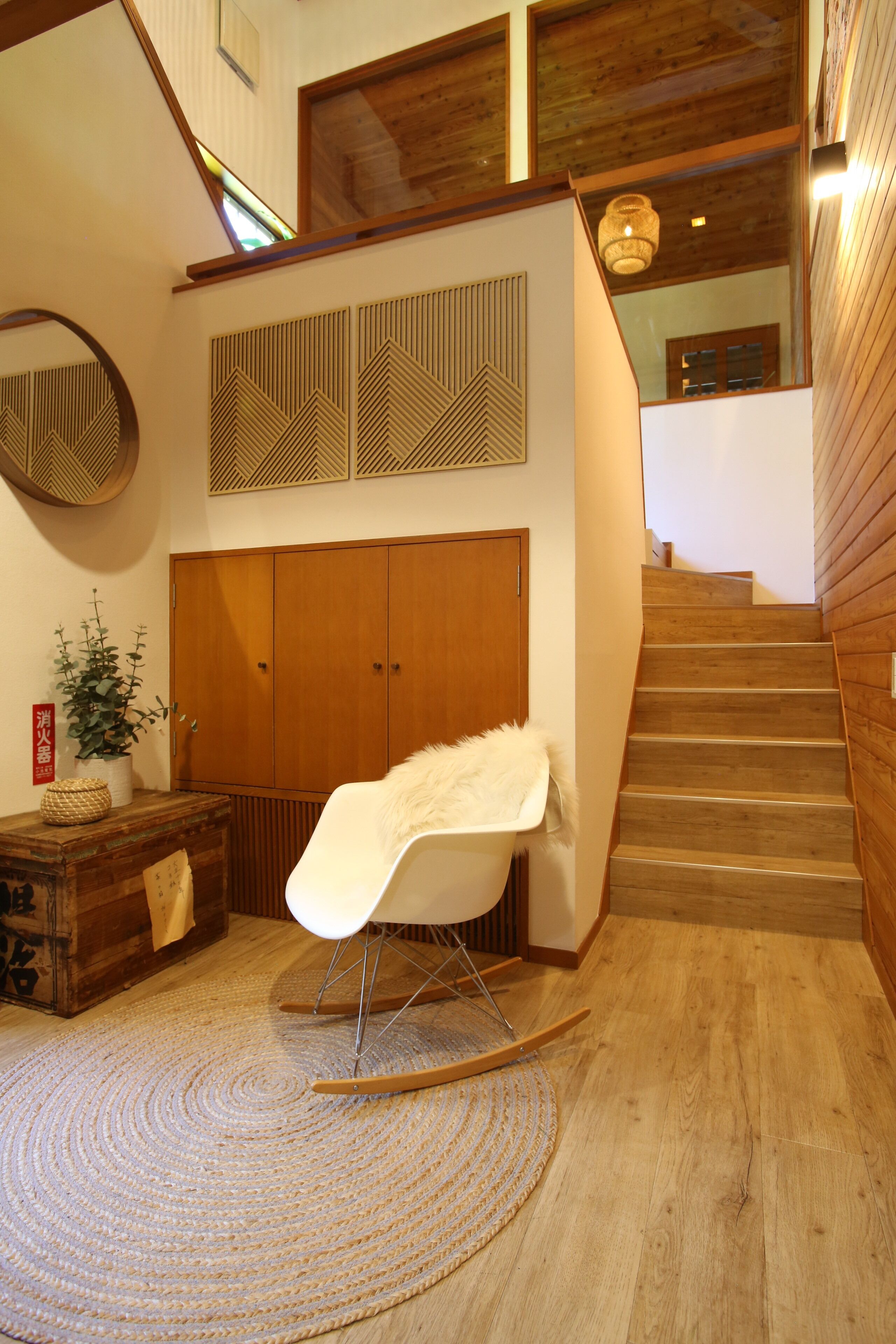A wooden staircase with a white chair in a cozy room.