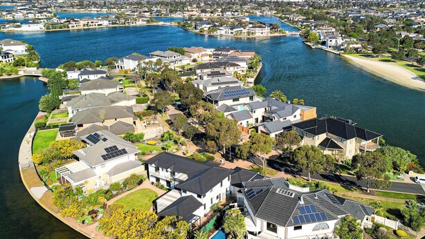 A residential area with houses along a curved waterfront, featuring solar panels on some roofs. - StayAU 6BR Deluxe Lakeview Point Cook (Point Cook)