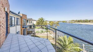 A balcony with a view of a river and beach. - StayAU 6BR Deluxe Lakeview Point Cook (Point Cook)