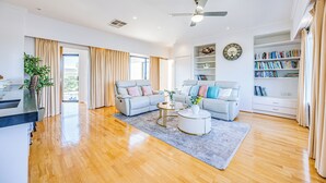 A spacious living room with two sofas, a coffee table, and a bookshelf. - StayAU 6BR Deluxe Lakeview Point Cook (Point Cook)