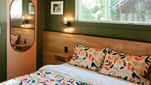 Un dormitorio con cama, ventilador de techo, ventana y espejo.