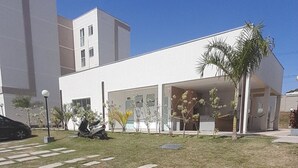 A modern building with a flat roof, large windows, and a paved courtyard with stepping stones.