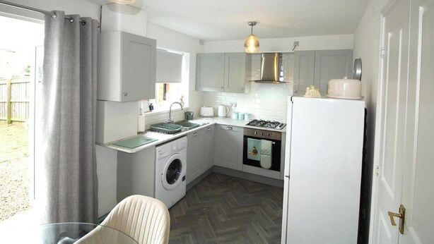 A compact kitchen with a washing machine, a stove, and a refrigerator. - House - Sleeps 4 - Pets Ok - Parking (Ashington)