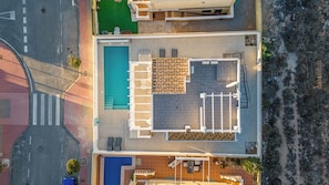 Luchtbeeld van een hotel met een zwembad, een terras en een overdekte patio.