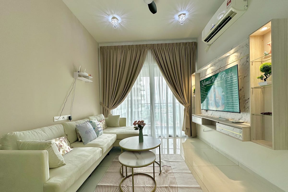 A modern living room with a sofa, a coffee table, and a TV mounted on the wall.