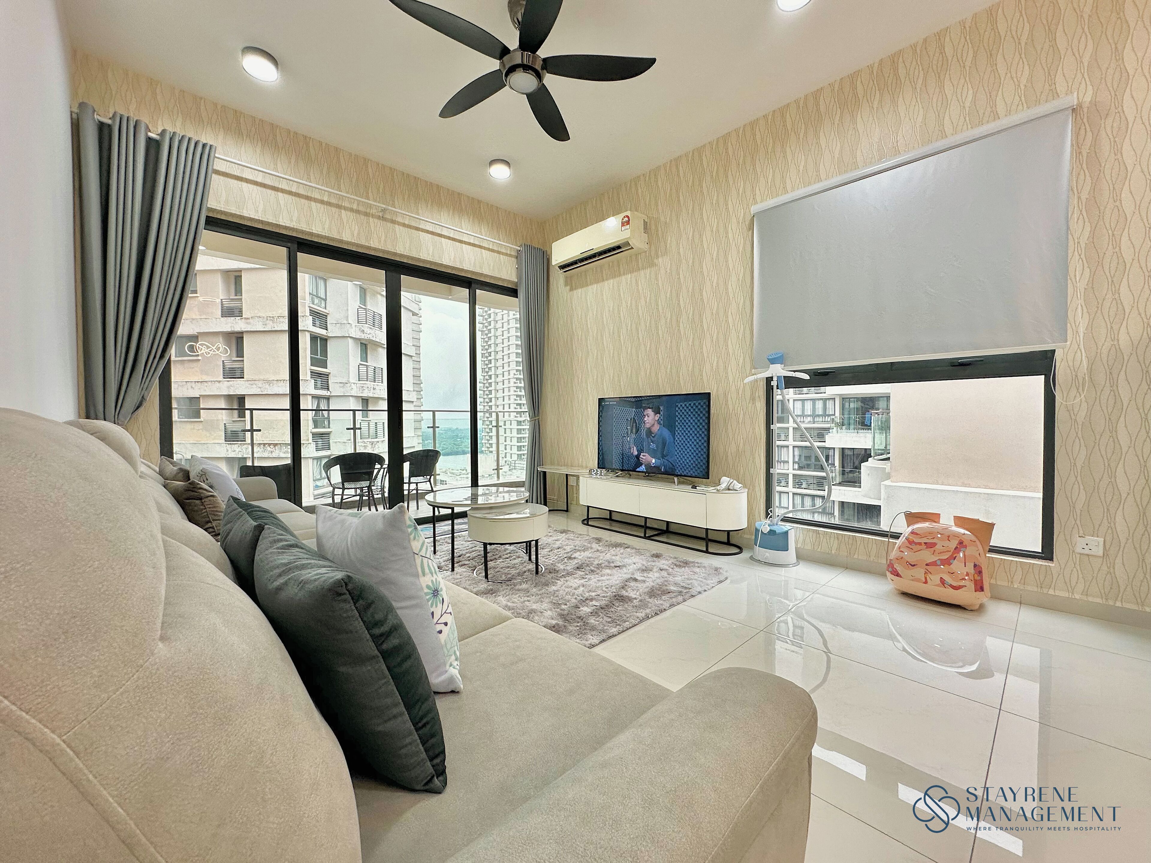 A modern living room with a sofa, TV, and a view of a cityscape.