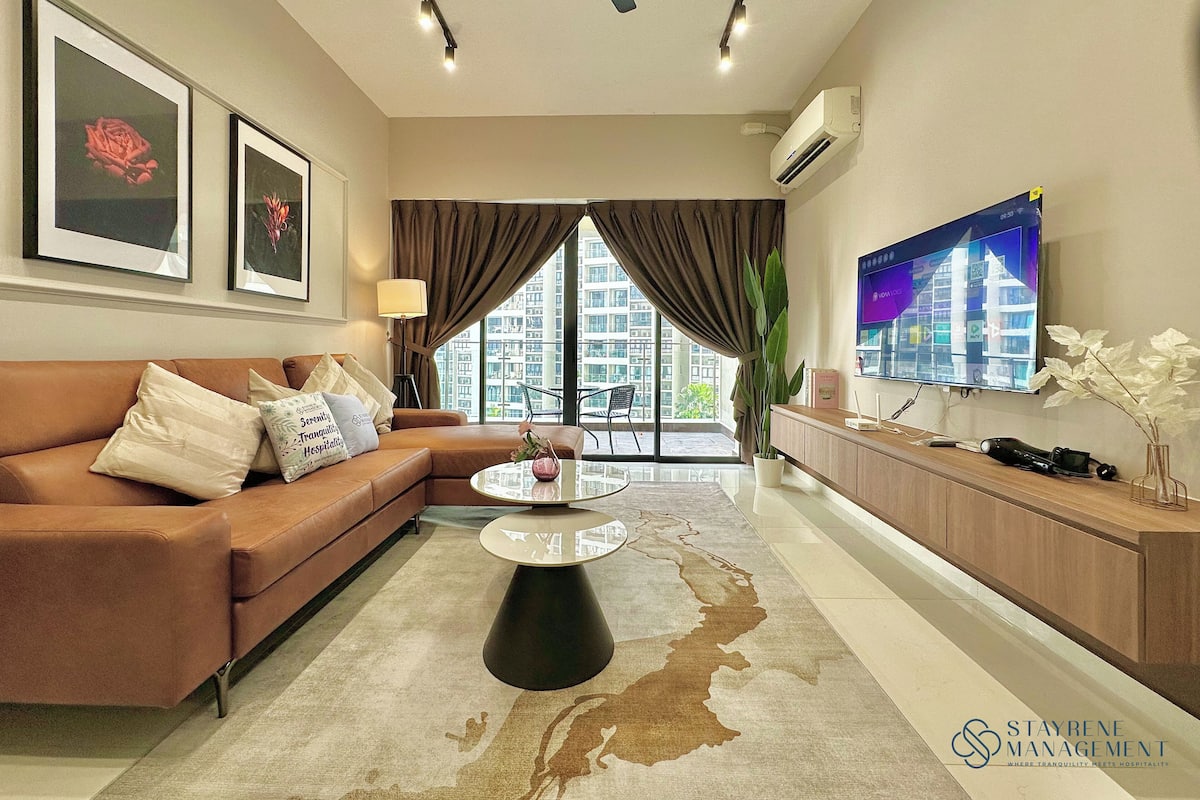 A modern living room with a brown sofa, a coffee table, and a TV on the wall.