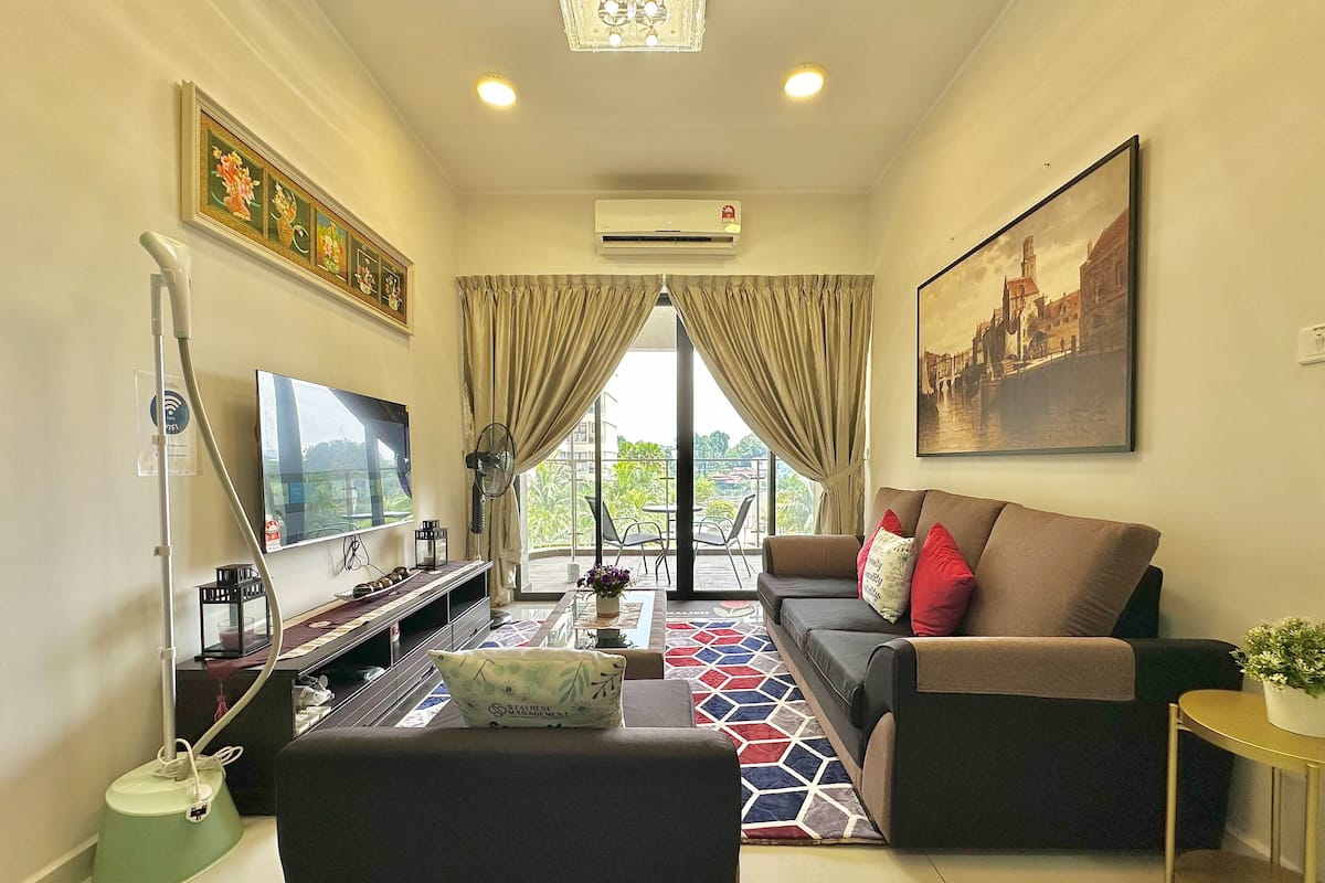 A modern living room with a sofa, TV, and a painting of a cityscape.