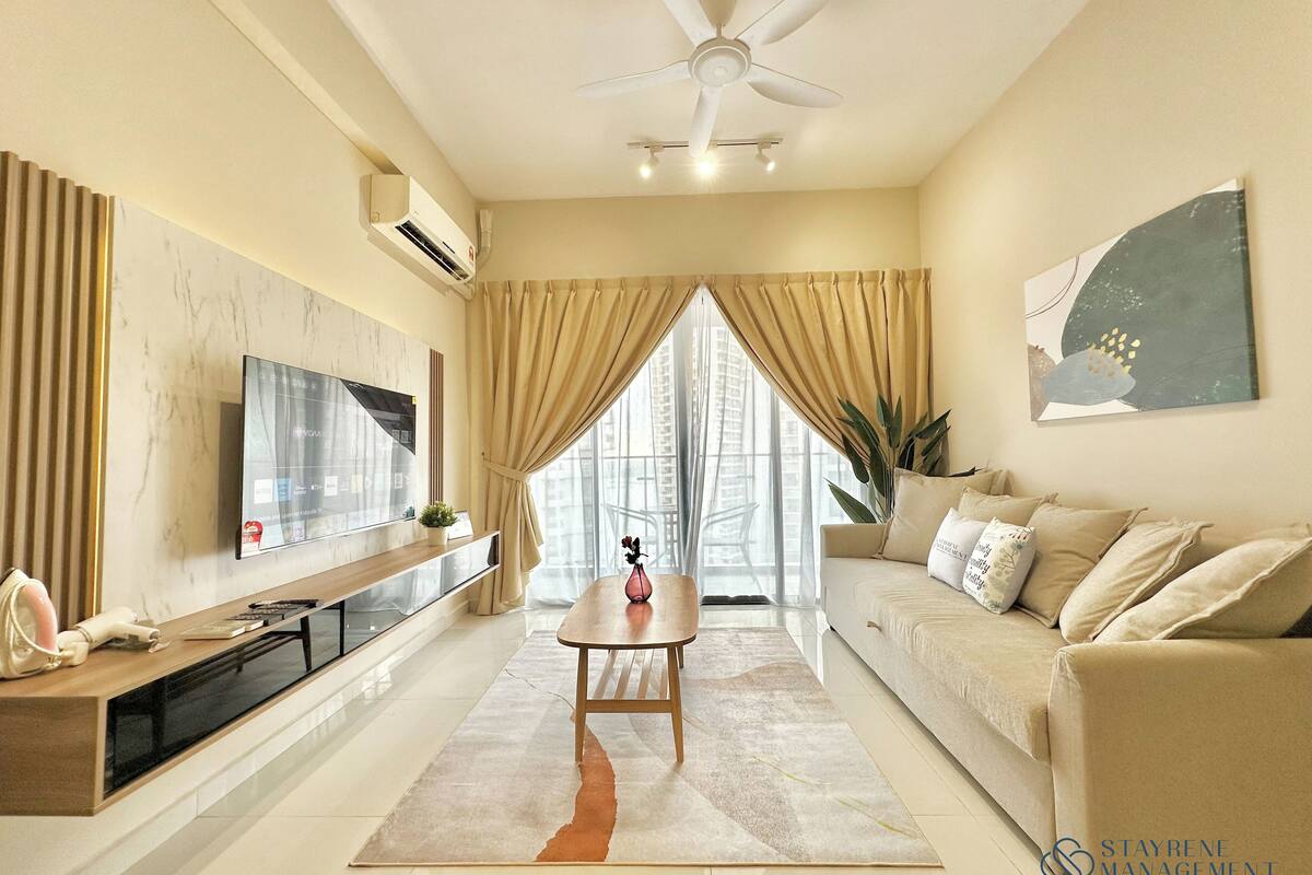 A modern living room with a flat-screen TV, a ceiling fan, a sofa, and a dining table.