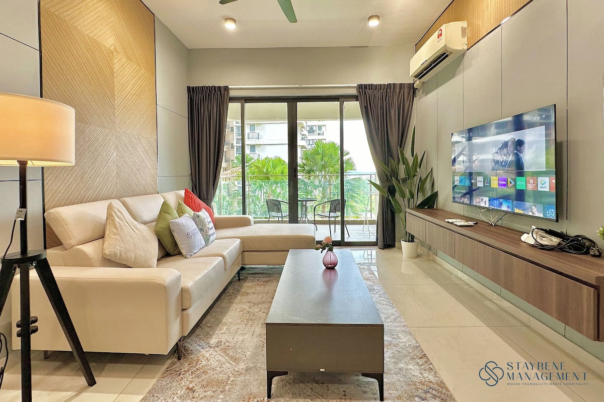 A modern living room with a sofa, coffee table, and a flat-screen TV.