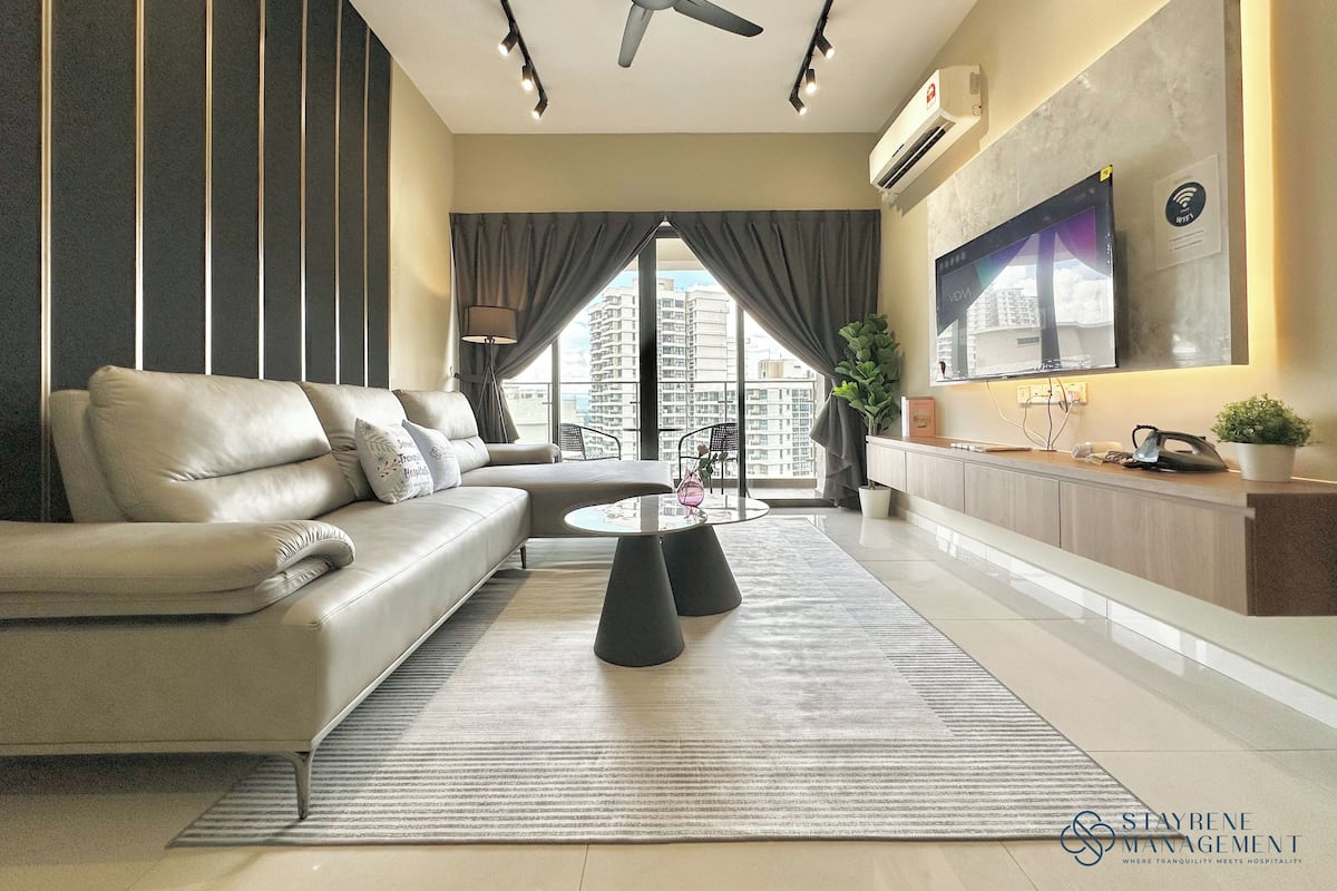 A modern living room with a sofa, a coffee table, and a TV mounted on the wall.