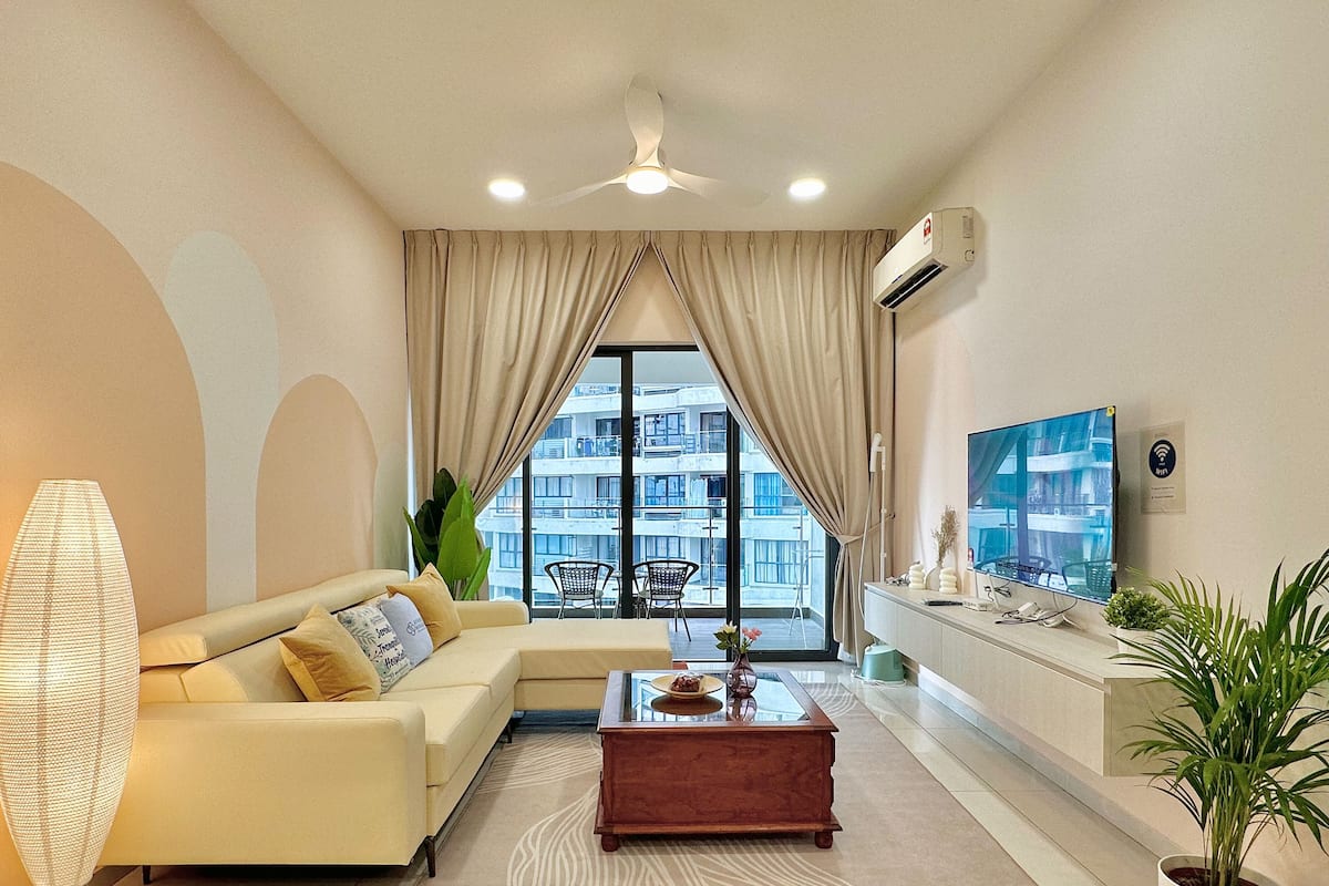 A modern living room with a sofa, coffee table, and a TV.