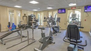 A gym with various exercise equipment, including treadmills, stationary bikes, and weight machines.