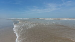 Une plage aux vagues douces et sous un ciel dégagé.
