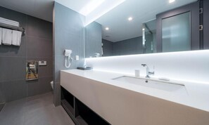 A modern bathroom with a long vanity, a large mirror, and a hairdryer on the wall. - Jeonju Hotel Davin (Jeonju)
