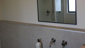 A bathroom with a green sink, a mirror, and a shower visible in the reflection. - Hinenamu Cottage -Two Bedroom and located in a quiet Cul de Sac! (Turangi)