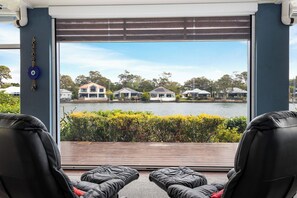 Relax in a serene indoor seating area with a stunning lake view and comfortable seating for two.
