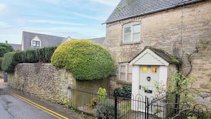 A stone house with a small attached shed, a stone wall, and a metal fence. - Honeypot Cottage-Lovely Bolthole in Stow (Cheltenham)