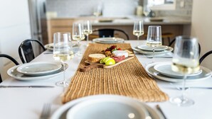 A dining table set with plates, glasses, cutlery, and a charcuterie board. - Creek House (Ocean Grove)