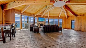 A spacious wooden interior with a stone floor, a dining area, and a seating area with a view of the water. - Kings Beach Escape w/ Patio & Pool Access (Kings Beach)