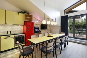 Una cocina moderna con comedor, un electrodoméstico rojo y un ventanal grande.