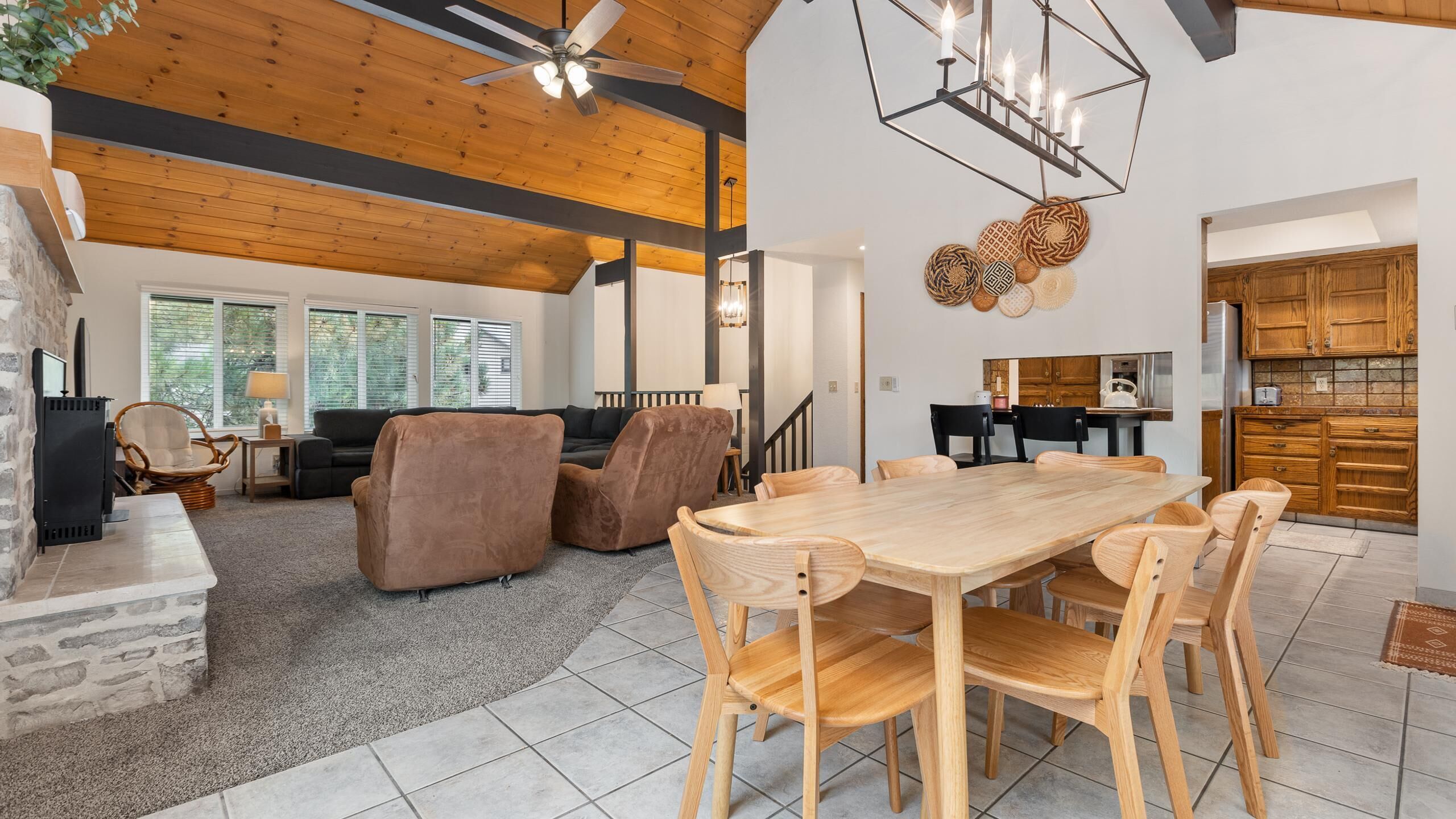 Amplia sala de estar con una mesa de comedor de madera, asientos cómodos y una cocina con armarios de madera.