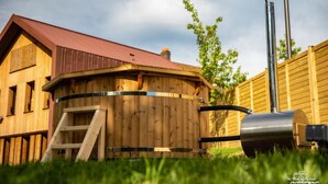 A wooden structure with a red roof, a metal grill, and a solar panel. - Logis Hotel Le Chalet Altitude (Pierre-Percée)