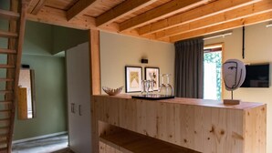 A wooden interior with a built-in desk, framed pictures, and a mirror. - Logis Hotel Le Chalet Altitude (Pierre-Percée)