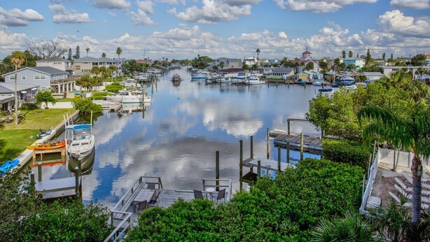 A marina with boats docked, surrounded by residential houses and greenery.
