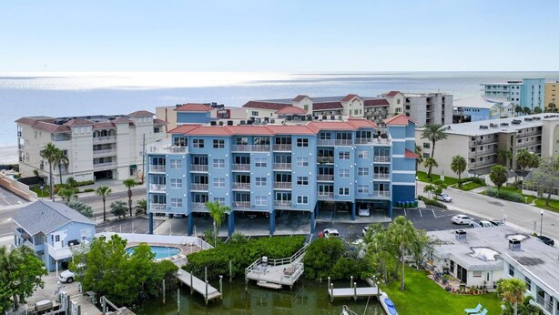 Un hotel de varios pisos con balcones, piscina y puerto deportivo.