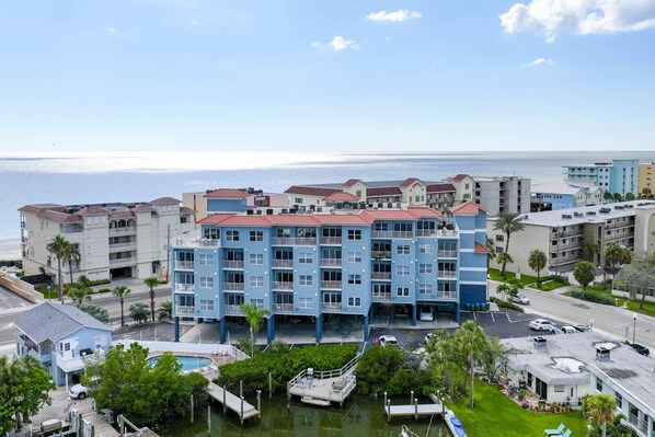 Un hotel de varios pisos con balcones, piscina y puerto deportivo.