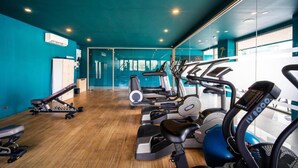 A gym with cardio machines, weight benches, and a mirrored wall. - Sea View Suite C64 in Oceana near Beach (Kamala)