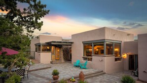 A modern building with a patio area, outdoor seating, and a stone wall. - Mystic View: A 3-bedroom, 3-bath house in West Sedona close to trails & dining (Sedona)