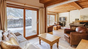 A cozy living room with a fireplace, a television, and a dining area with a table set for four.
