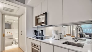 Uma cozinha moderna com armários brancos, forno embutido, cafeteira e torradeira.
