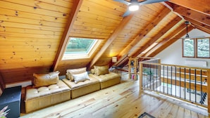 Un interno in legno con un divano, una ventola a soffitto e una scala.