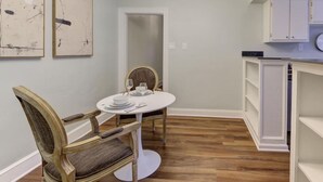 A dining area with a round table, a wooden chair, and a modern chandelier. - Sweet Stay in Memphis (Memphis)