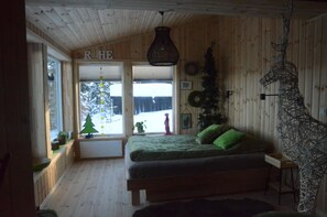 Relax in a spacious room with a large bed, a bedside table, and a unique sculpture on the wall.