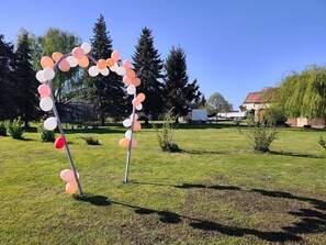 Un espace extérieur verdoyant agrémenté d’une arche décorative faite de ballons.
