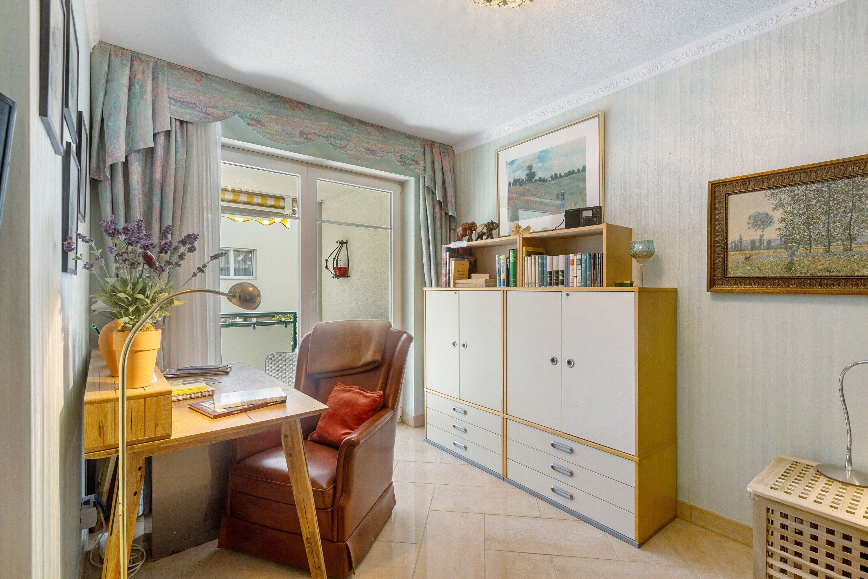 Ein Zimmer mit Schreibtisch, Stuhl, Kleiderschrank und einem Blumentopf.